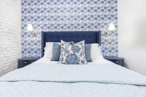 路易斯威尔Lavish Blue Suite 5 with Hollyhock的一间卧室配有蓝色和白色壁纸的床