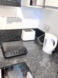 牛津A Comfortable Room in a Friendly Home in Headington, Oxford的厨房柜台配有电话和烤面包机。