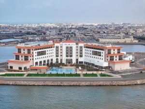 吉布提Djibouti Ayla Grand Hotel的水边白色大建筑的空中景观