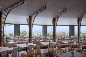 马斯蒂查里Ammos Luxury Resort的餐厅设有桌椅和窗户。