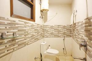 新德里Hotel Red Stone Mahipalpur的一间带卫生间和镜子的小浴室