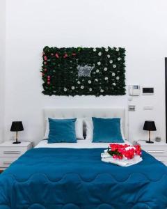 莱切Davids Room Palazzo Tamborino的一间卧室配有一张带鲜花的蓝色床