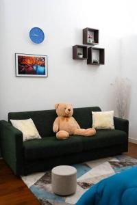 莱切Davids Room Palazzo Tamborino的坐在绿沙发上的泰迪熊