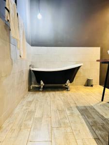 利隆圭The Shed Venue & Boutique Hotel的铺有木地板的客房内设有浴缸。