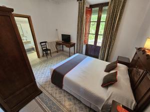 兰哈龙Hotel España的一间卧室配有一张床、一张书桌和一个窗户。