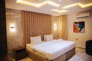 拉各斯DE LEVERAGE HOTEL & SUITES的卧室配有一张白色大床