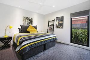 穆尔瓦拉The Sinatra Couples Retreat的一间卧室配有一张带黄色枕头的床和一扇窗户