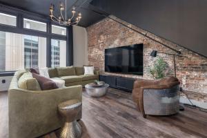 路易斯威尔Penthouse Grand Executive Suite的一间设有砖墙和电视的客厅