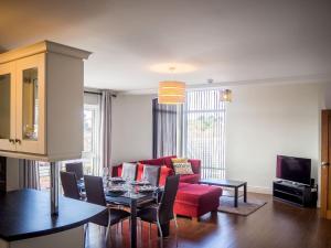 卡拉罗Carraroe Apartment的客厅配有红色的沙发和桌子