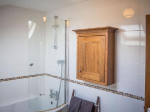 卡拉罗Carraroe Apartment的带淋浴和浴缸的浴室以及橱柜。