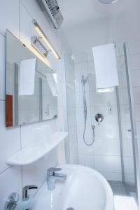 施瓦格明德Pension Krone的白色的浴室设有水槽和淋浴。