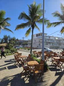 里约热内卢Surf'O Hostel的一组木桌和椅子,还有一棵棕榈树