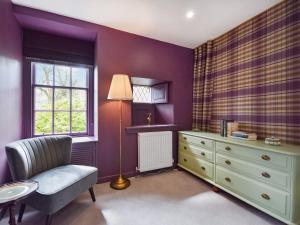 福克兰Moncrieff House的一间卧室设有紫色墙壁、椅子和梳妆台