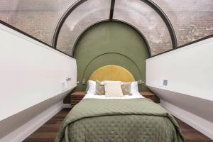 路易斯威尔Modern Mid Century Getaway. Luxury by Hollyhock的一间卧室设有一张大床和拱门