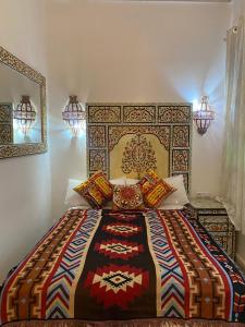 丹吉尔Zoco Riad的一间卧室配有一张大床和彩色床罩
