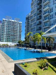 Lapu Lapu CityOne Pacific Residence SeaView Condo Mactan Newtown Lapu-Lapu City的一座棕榈树和高楼的大型游泳池