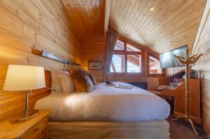 拉普德兹Hôtel Au Chamois d'Or by Les Etincelles的小木屋内一间卧室配有一张白色大床