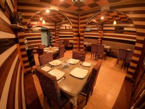 大吉岭Hotel Broadway Mall Road Darjeeling - Family Joy Vacations & Best Location的一间在房间内配有桌椅的餐厅