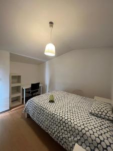 波尔图Vale Formoso Guest House的一间卧室配有一张床、一盏灯和一张书桌