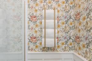 路易斯威尔Fancy Heart of Kentucky Suite的浴室内带花卉壁纸的毛巾架