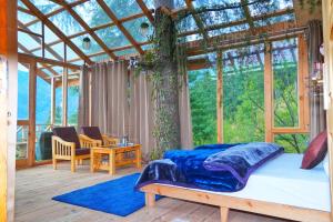 SainjStargazing Treehouse Himachal的一间卧室设有一张床和一个大窗户