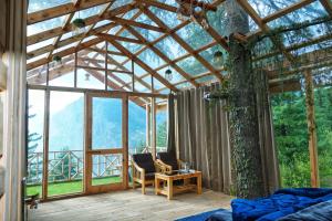 SainjStargazing Treehouse Himachal的配有床、椅子和桌子的房间