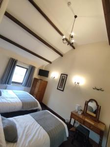 BradwellYe Olde Bowling Green Inn的一间卧室配有两张床和镜子
