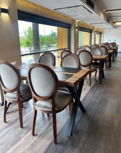 阿克恰阿巴德Sera Lake Center Hotel的房间里的一排木桌和椅子