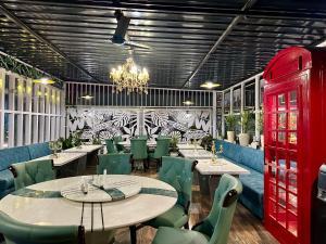 BāghdograYKC FARMS的餐厅设有桌子、绿色椅子和吊灯