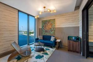迪拜Hyatt Centric Jumeirah Dubai - Executive Room - UAE的客厅设有蓝色的沙发和大窗户