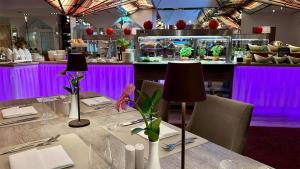 KremmenHotel & SPA Sommerfeld - Adults Only的餐厅配有紫色灯光和桌子