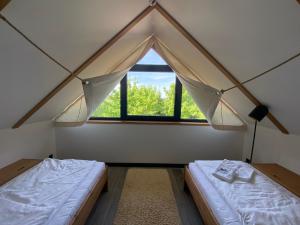 GdówDomki Kuter Port的客房设有两张床和窗户。
