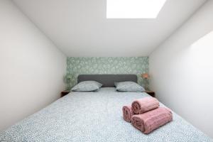 里昂Casa Azul - Belle maisonnette colorée - Garibaldi的一间卧室配有一张带两个粉红色枕头的床