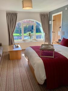 比代尔The Garden Suites at Snape Castle Mews的一间设有大床和窗户的酒店客房