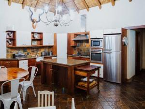 WolmaranstadBona Bona Game Lodge的厨房配有桌子和不锈钢冰箱。