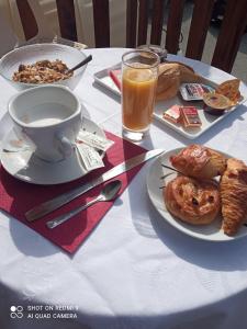 科尔普Hôtel du tilleul的餐桌,上面放着一盘食物和一杯橙汁
