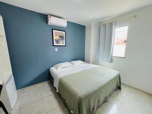 圣路易斯Belaris Hotel antes Hotel Costa do Calhau的一间卧室配有一张蓝色墙壁的床