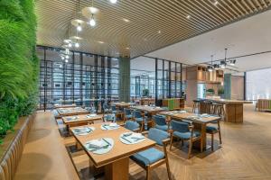 银川银川阅海逸衡酒店的餐厅设有木桌和椅子,种有植物