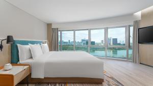 银川银川阅海逸衡酒店的卧室设有一张白色大床和大窗户