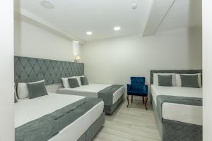 伯萨BURSA GRAND FAMİLY HOTEL & SpA的一间卧室配有两张床和一张蓝色椅子