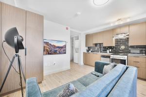 多伦多Skye Residences的一间带蓝色沙发的客厅和一间厨房
