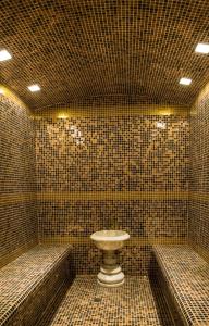 杜尚别HOTEL DIOR的瓷砖浴室设有卫生间和2个长椅