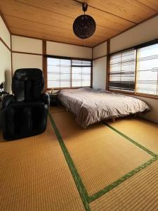 Yobitoアラン別邸自然溢れる呼人の一軒家的一间卧室配有一张床和一把椅子