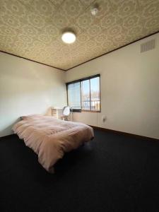 Yobitoアラン別邸自然溢れる呼人の一軒家的一间卧室设有一张床和一个窗口