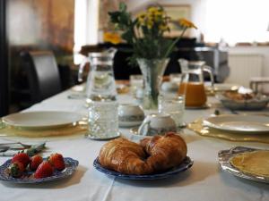 的里雅斯特达乐拉住宿加早餐旅馆的桌子上摆放着草莓和羊角面包的桌子