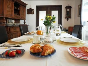 的里雅斯特达乐拉住宿加早餐旅馆的盘子里放羊角面包面包和水果的桌子