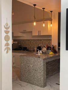 达赫拉Havre de Douceur Maison Cosy Confort et Style的厨房配有花岗岩台面和白色橱柜