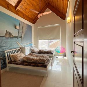布尔班Swiss Cottage Bhurban的一间卧室设有两张床,窗户设有船只