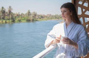 阿斯旺Five Star Nile Cruise from Aswan to Luxor的站在桥上的女人,喝杯咖啡