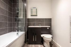 罗瑟勒姆Contemporary Studio Apartment in Central Rotherham的浴室配有卫生间、盥洗盆和浴缸。